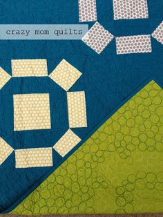 a blue quilt with white and green designs on it that says crazy mom quilts