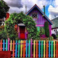 a colorful house with a picket fence around it