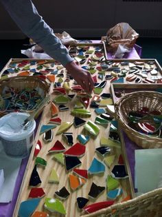 a table topped with lots of different colored pieces of glass on top of wooden boards