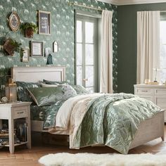 a bedroom with green walls and white furniture