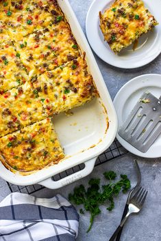 a casserole dish with meat and vegetables in it on a cooling rack next to two plates