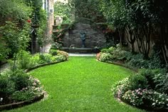 a lush green yard with lots of flowers and greenery on both sides of the walkway