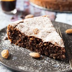 a piece of chocolate cake on a plate with almonds