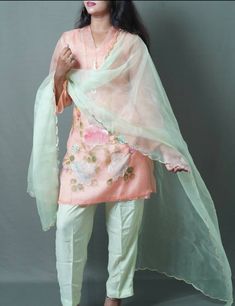 3 pc suit consisting of peach kurta, light green pant, and light green chiffon dupatta Delicately hand painted organza kurta with beautifully designed floral patterns on daman and sleeves Kurta styled with three quarter sleeves and heavy tassel hanging pearl lace on neck Duppata enhanced with curved golden pippin on all borders Number of components sold: 4 (Kurta comes with inner) Measurement in the size guide are all body measurements Spring Pista Green Chanderi Palazzo Set, Spring Silk Sharara With Sheer Dupatta, Silk Sharara With Sheer Dupatta For Spring, Spring Chanderi Sharara, Spring Anarkali Tissue Silk Kurta, Traditional Tissue Silk Sets For Spring, Green Gota Work Dupatta For Spring, Spring Chanderi Kurta With Sheer Dupatta, Spring Kurta With Sheer Dupatta In Chanderi