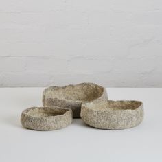 three stone bowls sitting next to each other on a table