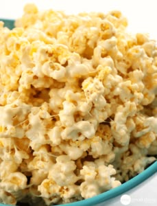 a blue bowl filled with popcorn on top of a table