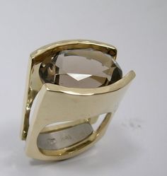 A simply stunning engagement ring that is made to last forever. Comes with a lifetime warranty. Very chunky looking on a size 4 finger. I can keep proportions the same for larger ring sizes by using a larger stone. I design and create your engagement ring with love in my Waterton based studio.  Specific details: 18 kt. yellow  8 mm to 14mm wide band 12 x 16 mm oval smoky quartz High Polish finish with hammer forged detail I will  craft the ring in my goldsmith workshop. Made to measure in all ring sizes. Ready to ship in 6 to 8 weeks. Please have your ring size measured at your local jeweller so you will receive the right size.  Other options are possible. I am happy to send you the price estimate! * Choose the color you prefer. The ring can also be created out of yellow or rose gold.  * C Luxury Hand Cast Engagement Rings, Luxury Contemporary Rings With Polished Finish, Luxury Contemporary Ring Jewelry, Luxury Brushed Finish Engagement Rings, Luxury Untreated Modern Rings, Luxury Modern Hallmarked Rings, Luxury Modern Rings With Shiny Finish, Luxury Contemporary Rings For Women, Luxury Polished Finish Ring