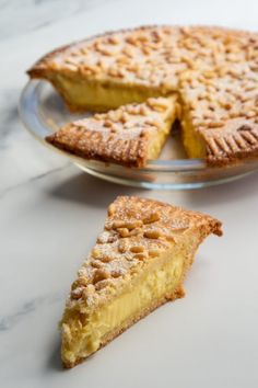 a piece of pie sitting on top of a glass plate next to a slice of pie