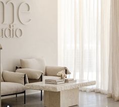 a living room filled with furniture next to a wall mounted art piece on the wall