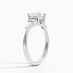 an engagement ring with three stones on the top and bottom, set in 18k white gold