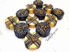 chocolates with gold and black decorations are arranged in the shape of heart shaped boxes