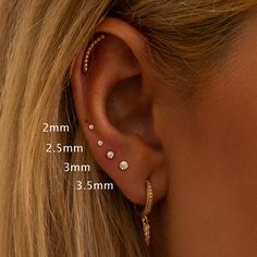 a woman's ear is shown with three different piercings