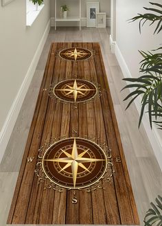 a wooden floor with three gold compasss on it and plants in the corner next to them