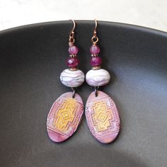 These pink and orange ethnic earrings feature embossed polymer clay components. The polymer ovals have a geometric design. They are accented with faceted hot pink quartz beads, copper spacers and pink Czech glass beads. These light weight earrings measure approx. 3 inches long dangling on bright copper earring hooks. Return to shop: bstrung.etsy.com More links where you can find me: Facebook: http://www.facebook.com/bstrung Pinterest: http://pinterest.com/bstrung Instagram: https://www.instagram Bohemian Polymer Clay Nickel-free Earrings, Bohemian Nickel-free Polymer Clay Earrings, Purple Hand Painted Bohemian Earrings, Bohemian Hand Painted Purple Earrings, Artisan Polymer Clay Earrings, Bohemian Hand Painted Polymer Clay Earrings, Hand Painted Bohemian Polymer Clay Earrings, Bohemian Polymer Clay Earrings, Moon Face Earrings