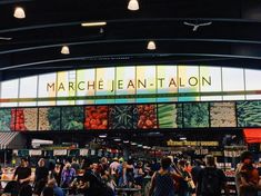 many people are standing in front of the sign for marche jean - it allon