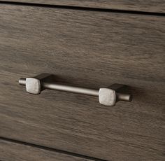 a close up of a drawer handle on a wooden cabinet with white marble knobs