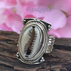 This stunning Cowrie Shell Gemstone Ring is made of polished, textured, and oxidized sterling silver with a handcrafted sterling silver ring setting. The ring has a beautiful and unique design with a high polish that gives the ring a luxe look. This friendship Gift is perfect for everyday wear and is sure to be a conversation starter. Metal : 925 Sterling Silver Weight (Gms) : 9 Gms Approx Style : Cocktail Ring Size :  All Sizes Healing Properties : ------------------------------------------------------------------------------------ The cowrie shell has many uses and meanings. ... Spiritually, according to African legend, if you are attracted to cowrie shells you could be family to an Ocean Spirit of wealth and earth. It also represents Goddess protection which is very powerful and connect Bohemian Engraved Toe Ring, Handmade Bohemian Ring For Anniversary, Bohemian Handmade Rings For Anniversary, Bohemian Carved Sterling Silver Jewelry, Bohemian Rings With Oxidized Finish For Anniversary, Bohemian 925 Stamped Toe Rings, Bohemian Sterling Silver Ring With Oxidized Finish, Bohemian Carved Ring Jewelry, Bohemian Engraved Rings As Gift