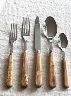 five forks, knives and spoons are lined up on a sheet