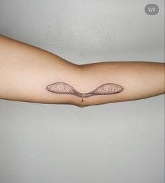 a woman's arm with a tattoo on it that has two wings flying in the air