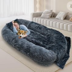 a woman laying on top of a dog bed