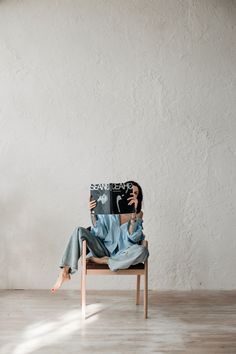 a woman sitting in a chair reading a book