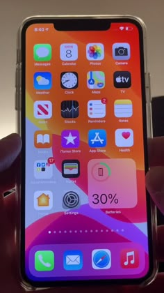 someone holding an iphone in their hand with icons on the screen and numbers below it