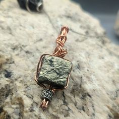 Raw Iron Pyrite Gemstone Pendant - Copper Wire Wrapped, Handmade Energy Stone Necklace, Unique Protective Talisman, Mens Jewelry  Raw Iron Pyrite cube wire wrapped in a braid using copper wire. one of my favorite pieces.  Pyrite is a stone of protection and intellect, enhancing mental clarity and shielding from negative energies.  This handcrafted piece is a beacon of empowerment, designed to accompany you on your journey to success. Artisan Jewelry With Raw Stone For Healing, Artisan Raw Stone Jewelry For Healing, Handmade Square Pendant Amulet Necklaces, Handmade Square Pendant Amulet Necklace, Raw Stone Amulet Pendant Jewelry, Wire Wrapped Amulet Jewelry For Meditation, Spiritual Bronze Healing Jewelry, Spiritual Bronze Jewelry For Healing, Spiritual Pendant Jewelry For Crafting