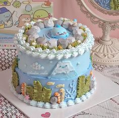 a blue and white cake sitting on top of a table next to a card board