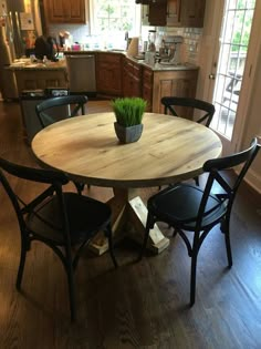 a kitchen table with chairs around it and a potted plant in the center on top