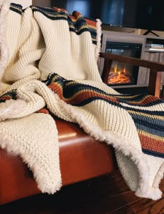 a blanket is sitting on top of a chair in front of a fire place and fireplace