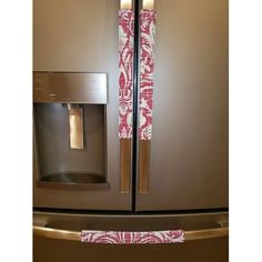 a metallic refrigerator with pink and white napkins on the door handle, next to an ice dispenser