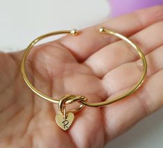 Personalized Bracelet, Gold Plated, Bangle Bracelet, Initial Heart, Engraved Heart, Bridesmaid Gift, Wedding Party, Initial Bracelet, Bangle Gorgeous gold plated bangle bracelet. It measures 54x62mm inner diameter. From the knot, it hangs a gold plated heart that can be engraved with an initial. Mix and match with other bracelets available in our store, for an effortlessly chic look! Also a perfect gift for your bff, your bridesmaids, or a special person in your life. Important! We are located i Heart Charm Bangle Bracelet For Wedding, Adjustable Heart Bangle Bracelet For Wedding, Wedding Heart Charm Bangle Bracelets, Wedding Bangle Bracelet With Heart Charm, Adjustable Heart Bracelet For Wedding And Mother's Day, Wedding Bracelet With Heart Charm, Gold Bracelets For Bridesmaid Gift On Valentine's Day, Gold Bracelets For Bridesmaids, Valentine's Day Gift, Gold Bracelets For Bridesmaid Gift