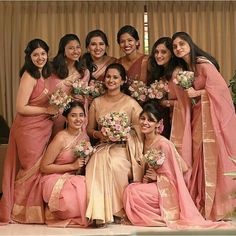 a group of women standing next to each other holding bouquets and smiling at the camera