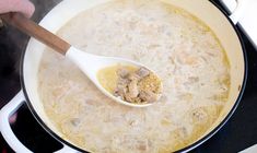 a wooden spoon in a pot filled with food