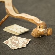 some cards are laying on the ground next to a piece of wood that has been turned into an object