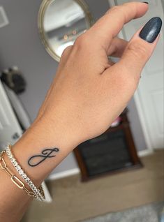 a woman's hand with a small tattoo on her left wrist and the word love written in cursive writing