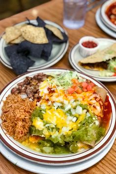 three plates with mexican food on them sitting on a table