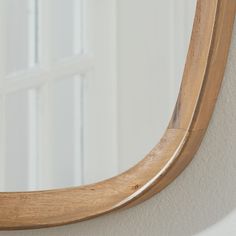 a wooden mirror hanging on the wall