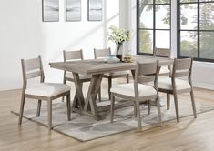 a dining room table with six chairs and a rug on the floor in front of it