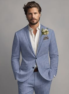 a man in a blue suit with a flower on his lapel and white shirt