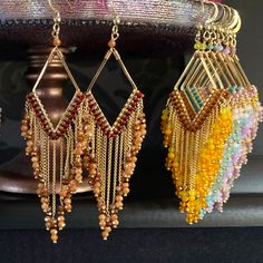 three pairs of beaded earrings hanging from a shelf