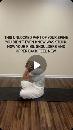 a woman sitting on top of a yoga mat in front of a wall with an inspirational quote