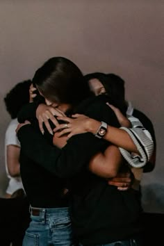 two women hugging each other in the middle of a room