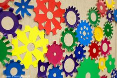 colorful gears are arranged on the wall in an art project for children to play with