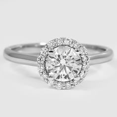 a white gold engagement ring with an oval diamond center