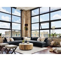 a living room filled with furniture and large windows