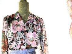 "Boho vintage 70s, soft, light polyester blouse. Made by Joanna in USA. Long sleeve. Couple pleats of the shoulder. V neck line with a collar. Closure up front with a tiny black, plastic buttons. Pastel watercolor print of the exotic flowers and leaves: lavender, pink, sage, olive green, brown, gray, beige, off white, black. Delicate, feminine, unique. Cute! Excellent condition, clean and strong inside and out. No any damage, no discoloration, no odor. Comfortable . Size 16. Length :24,0\" Shoul Spring Tropical Blouse With Floral Print, Tropical Floral Print Blouse For Spring, Spring Tropical Printed Blouse, Vintage Tropical Print Tops For Spring, Vintage Tops With Tropical Print For Spring, Long Sleeve Blouse With Tropical Print For Spring, Vintage Pink Blouse With Floral Print, Vintage Long Sleeve Pink Blouse, Vintage Long Sleeve Blouse With Abstract Print