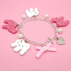 This frosted circus animal cookie bracelet is so whimsical, girly and fun, a perfect gift for any woman who loves cute charm jewelry, kawaii or pink. Handmade, the resin pendants are so realistic you may think they are real cookies! The cookie charms are on the larger side so this is definitely a statement piece. Available in your choice of gold or Silver finish.Details & Measurements: Pendants are hand-painted resin Pendants are 1.5" in size (3.75cm) Bracelet is 7.5" long (18.75 cm) Available in gold or silver finish Glass Pearls Baby Pink Bow Bead Finished with a Fatally Feminine Designs heart charm and toggle clasp Handmade More Animal Cookie Jewelry available, just search "animal Cookie"Shipping & Gift Options: item is handmade to order and will take around 1 week to process before shi Playful Dangle Personalized Jewelry, Cute Charm Bracelet With Removable Charms As Gift, Playful White Jewelry With Charms, Pink Kawaii Jewelry For Valentine's Day, Kawaii Pink Jewelry For Valentine's Day, Kawaii Bracelet Jewelry For Friendship, Cute Jewelry With Removable Charms For Friendship, Kawaii Friendship Bracelet Jewelry, Nickel-free Cute Jewelry For Party