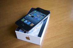 an iphone sitting in a box on top of a wooden table