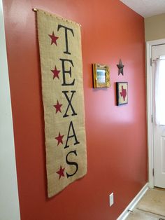 a red wall with a texas flag hanging on it